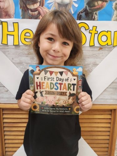 Child holding First Day of Head Start postcard